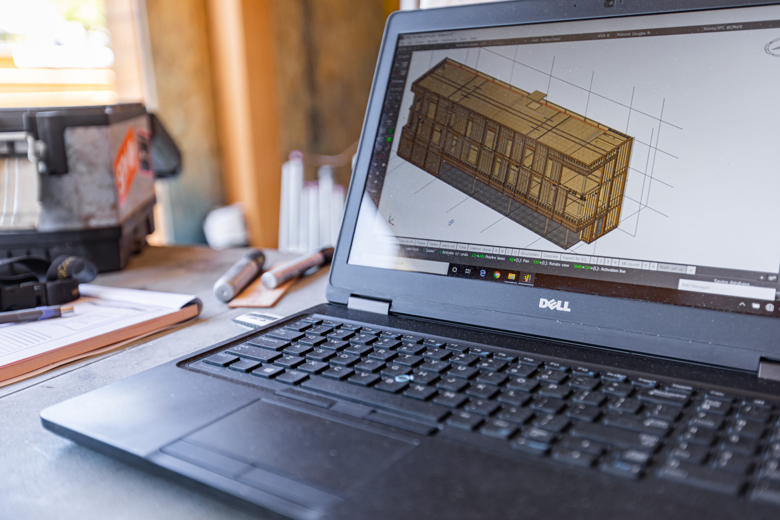 Laptop screen showing a 3D render of a building wood structure.