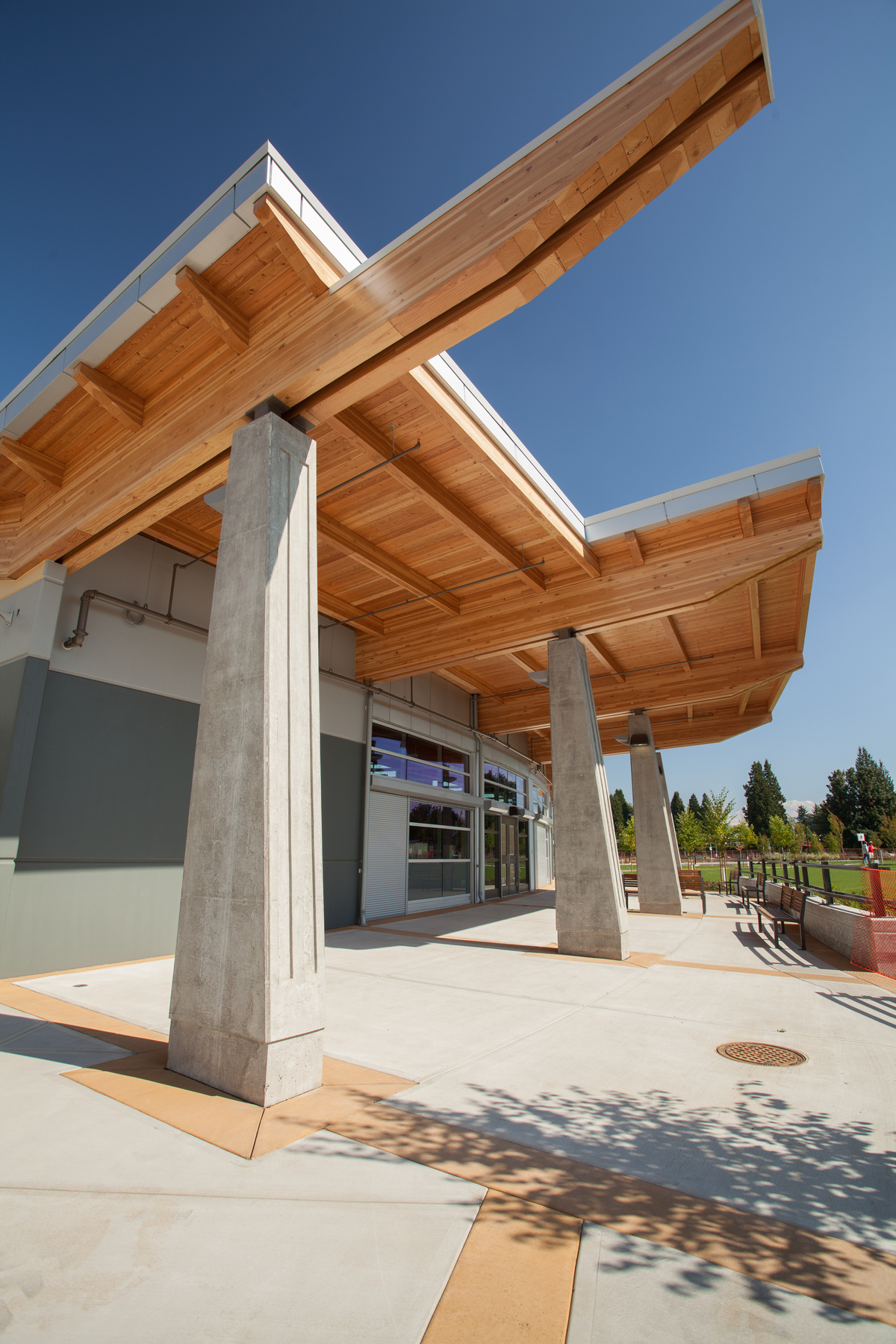 Exterior sunny daytime view of Abbotsford Senior Secondary School showing Glue-laminated timber (Glulam) beams supporting additional mass timber elements and lumber which makes up roof