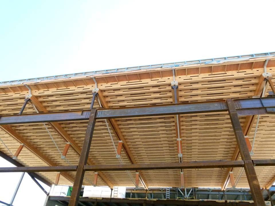 Exterior daytime view of multi storey Alberni District Secondary School during construction showing steel girders supporting numerous glue-laminated timber (Glulam) beams supporting lumber roof joists