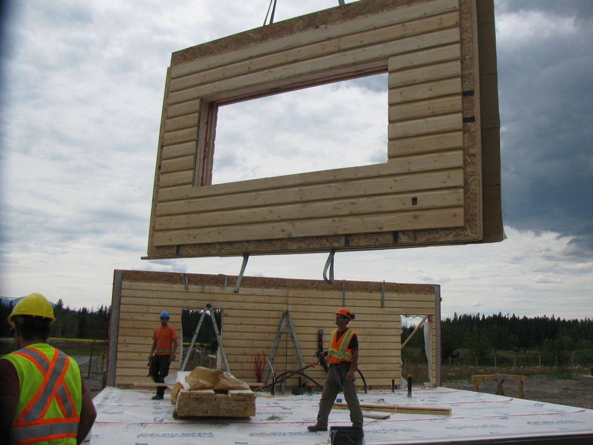 Early daytime Anahim Lake Airport Terminal construction images showing prefabricated Passive house / High performance wood panels being lowered into place