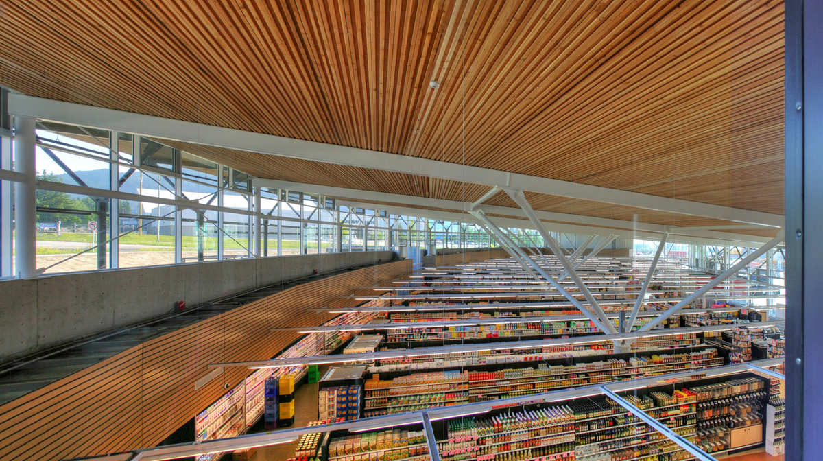Interior daytime view of Askews Uptown Market featuring 3,000-square-metre floating nail-laminated timber (NLT) roof structure