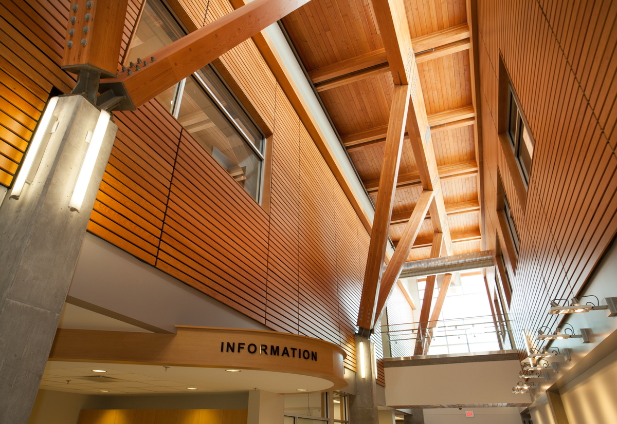 Interior daytime view of low rise BC Cancer Agency Centre for the North showing glue-laminated (glulam) timber, solid-sawn heavy timber, wood paneling and accents