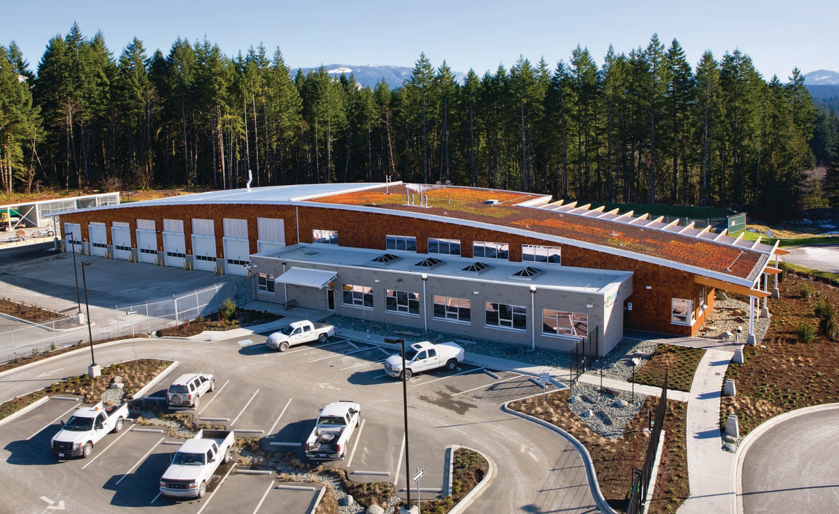 Sunny daytime exterior view of 2,100 square metre BC Hydro Operations Centre in Port Alberni showing wood exterior, including a roof of braced, steel frame supporting glue-laminated timber (glulam) beams on the main column lines