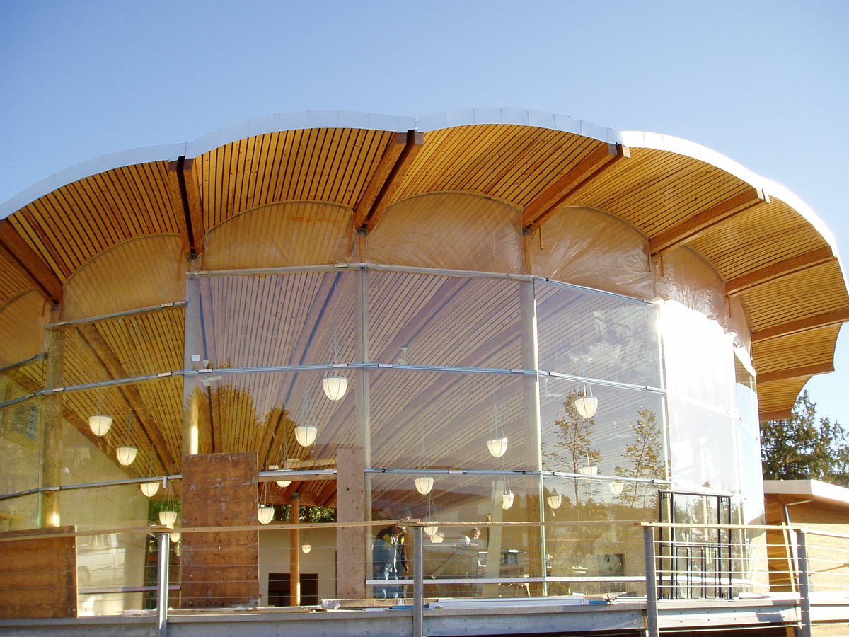 Daytime exterior view of Bamfield Marine Centre, looking in at scallop-shell-shaped wood roof with parallel strand lumber (PSL) bottom chords