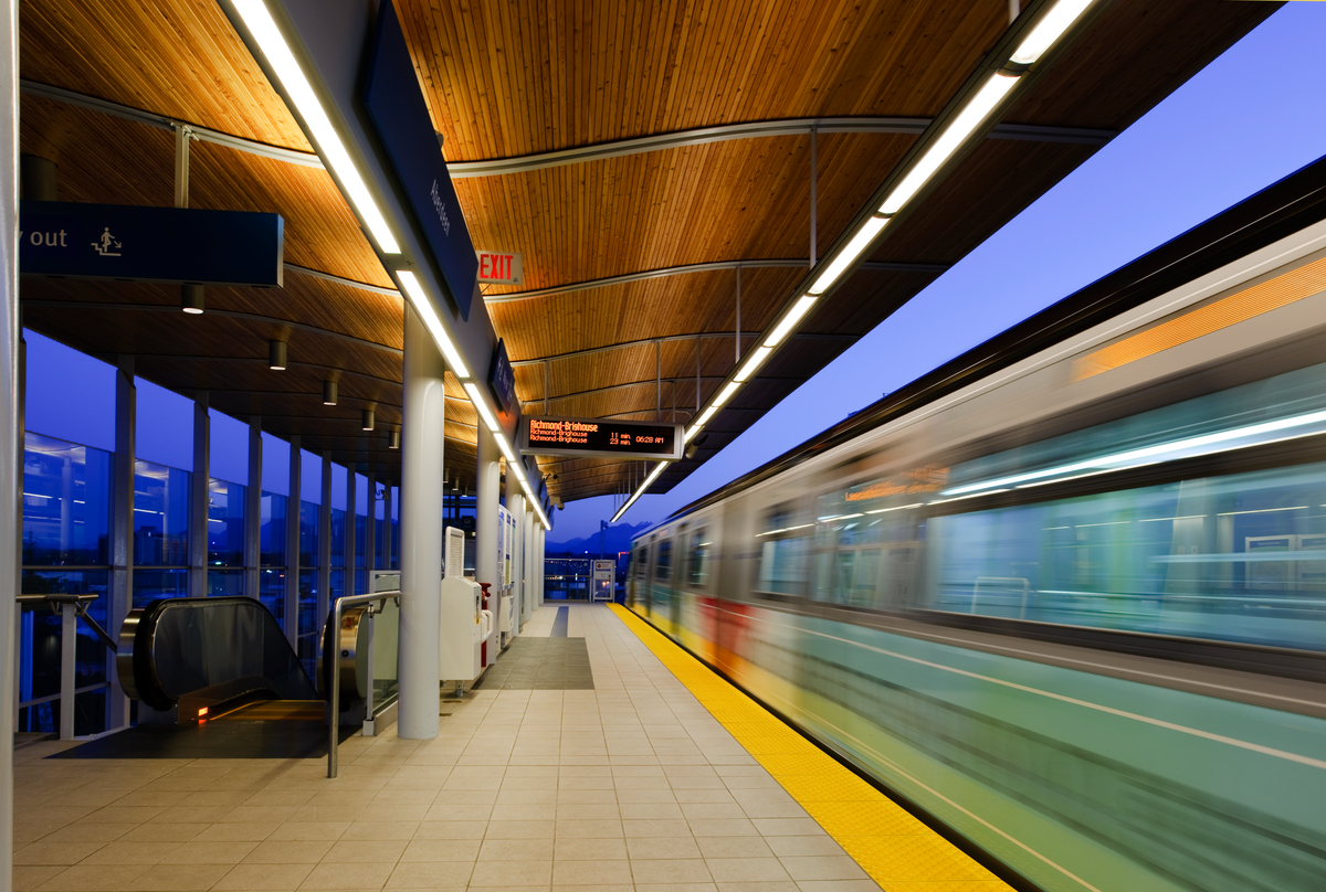 Aberdeen Canada Line Station at dusk with skytrain coming into the station, blurred
