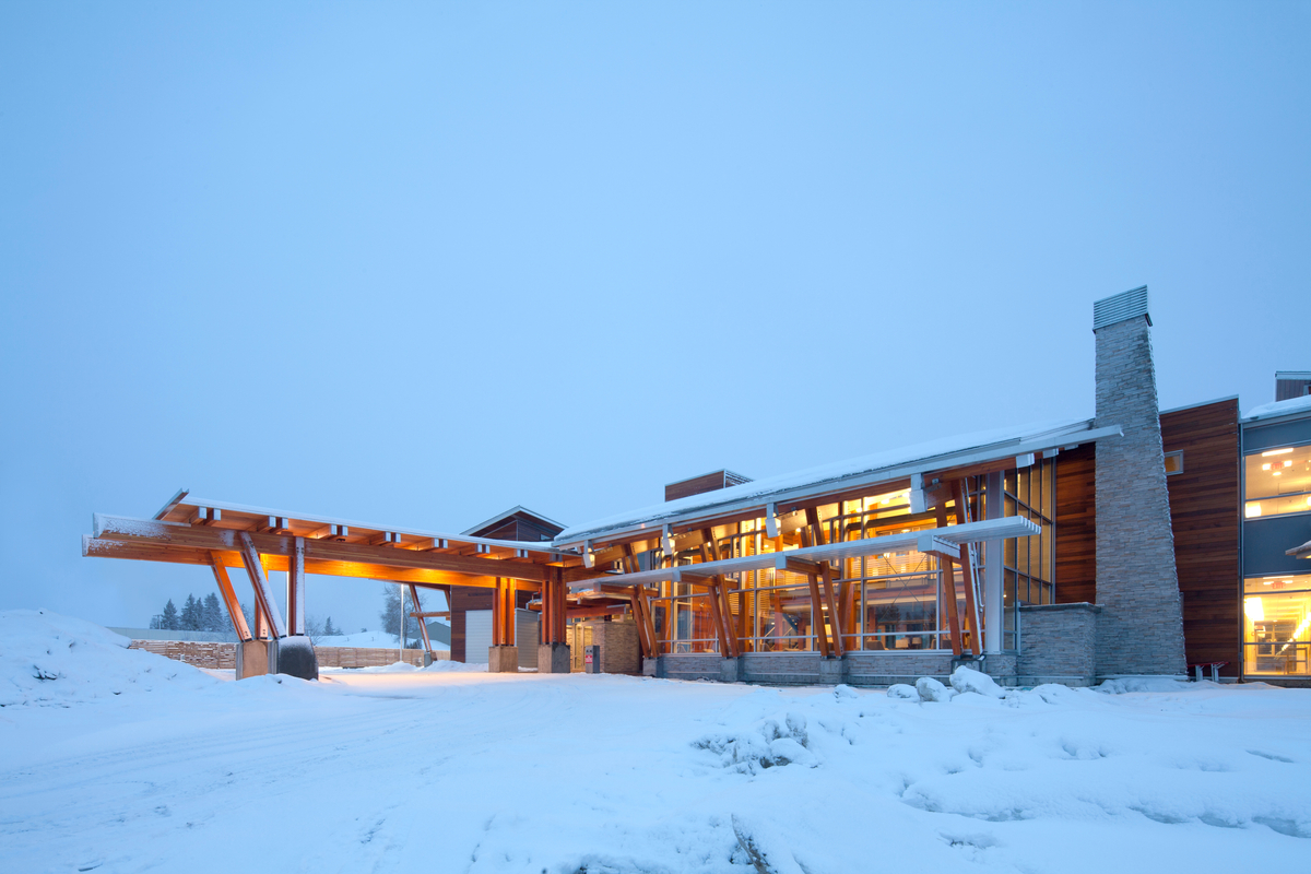 Exterior daytime snowy winter view of low rise two story Canadian Cancer Society Kordyban Lodge, showing Glue-laminated timber (Glulam), and decorative siding