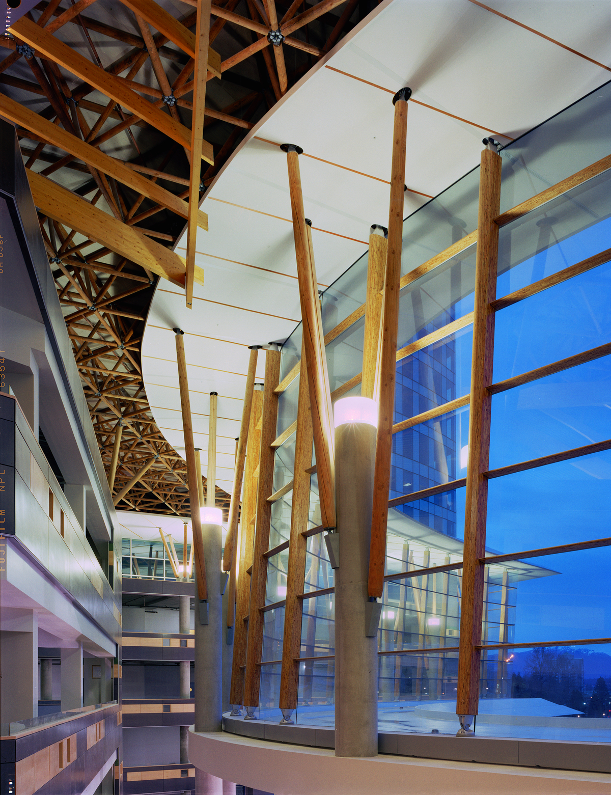 Interior evening view of Surrey Central City front facing showing multi storey glass supported by concrete and glue-laminated timber (Glulam), parallel strand lumber (PSL) and solid-sawn heavy timber
