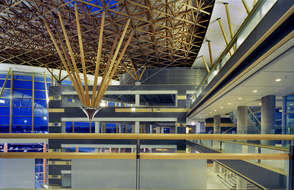 Interior evening view of Surrey Central City atrium showing multi storey glass front, balconies, and numerous elements including glue-laminated timber (Glulam), parallel strand lumber (PSL) and solid-sawn heavy timber