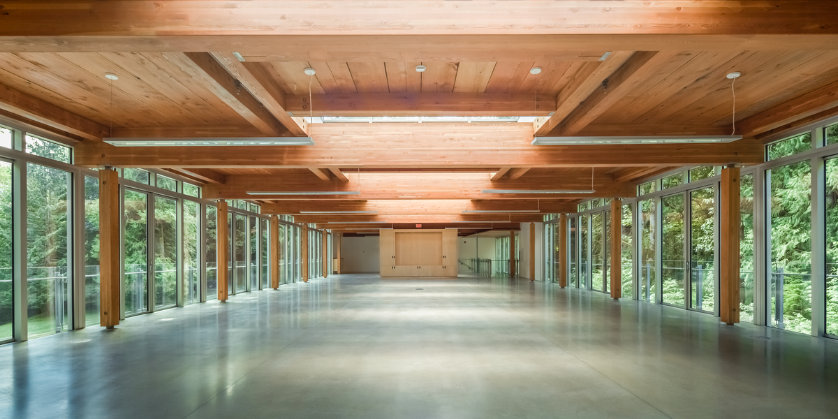 Daytime interior view of newly completed Cheakamus Centre Blueshore Environmental Learning Centre showing cross-laminated timber (CLT) glue-laminated timber (Glulam) beams supporting the plank roof system