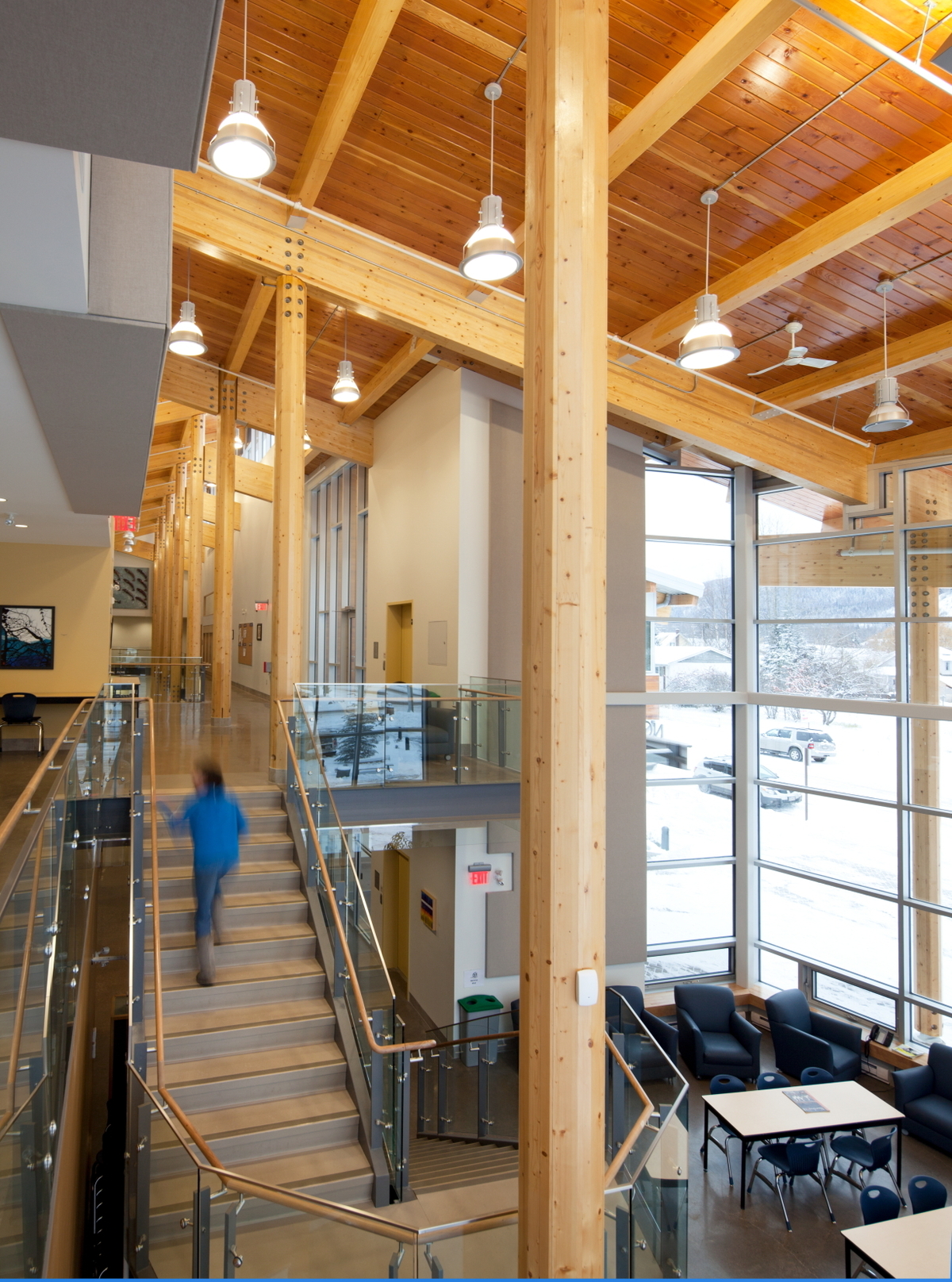 Interior daytime view of low rise hybrid construction Coast Mountain College upper floor, showing extensive use of glue-laminated timber (glulam), siding, solid-sawn heavy timber