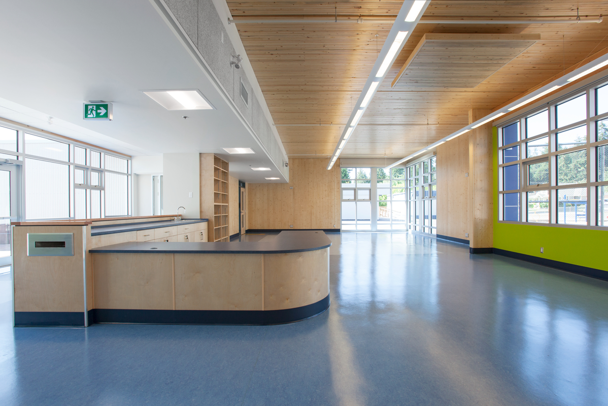 Interior daytime view of low rise Cordova Bay Elementary School showing wood paneling, ceiling, and accents throughout. Picture taken after seismic upgrades using nail-laminated timber (NLT) and cross-laminated timber (CLT)