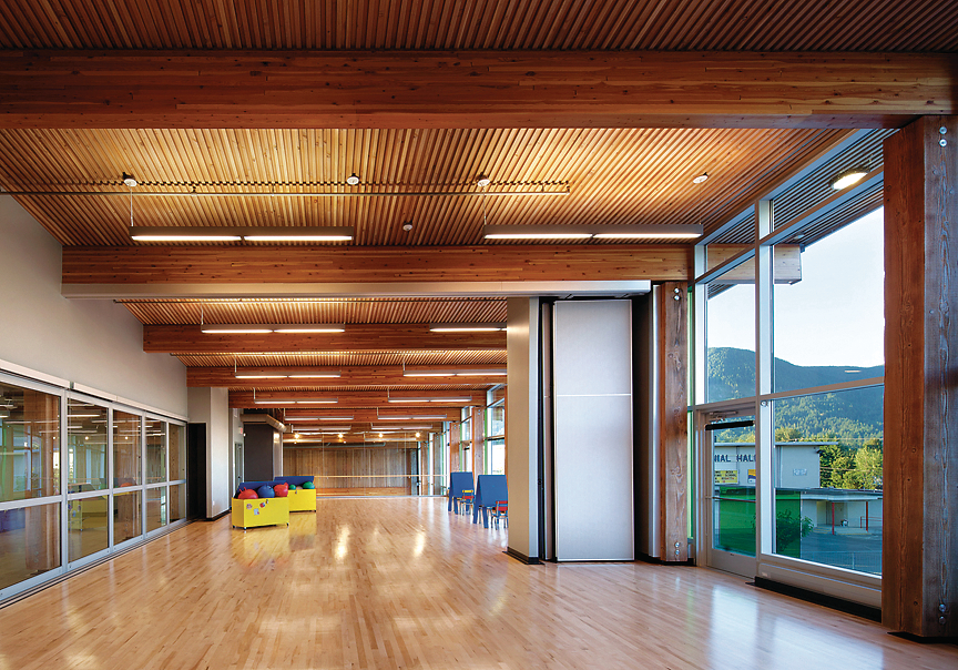 Interior view of Cowichan Lake Sports Arena, showing main access hall constructed with heavy timber, glue-laminated timber (glulam) beams, and solid-wood decking