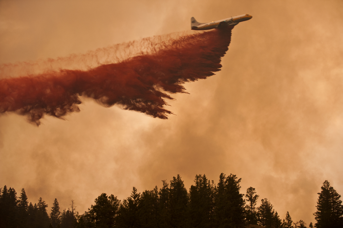 Lockheed L-188 Electra, owned by Air Spray, is shown dropping a 3000 gallon load of retardant on the Dog Creek forest fire in British Columbia