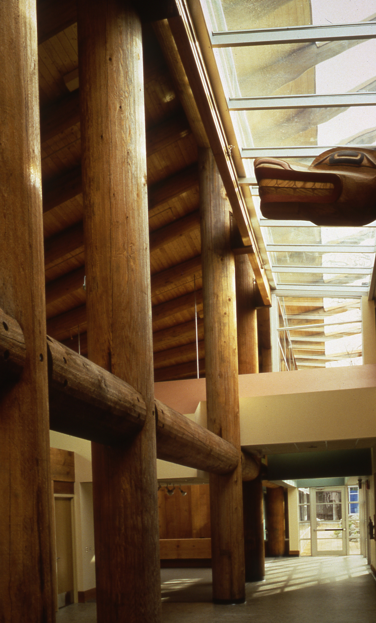 Indoor daytime image of First Nations Longhouse at The University of British Columbia showing massive timber pole beams and columns