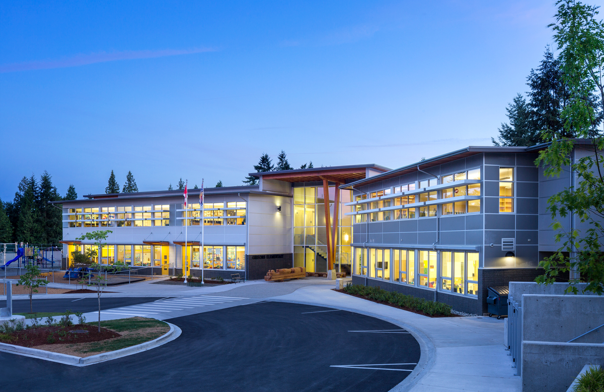 Exterior early evening image of low rise two-storey Gibsons Elementary School showing hybrid glass, steel, and wood aspects, including glue-laminated timber (glulam) beams and columns as the primary structural materials