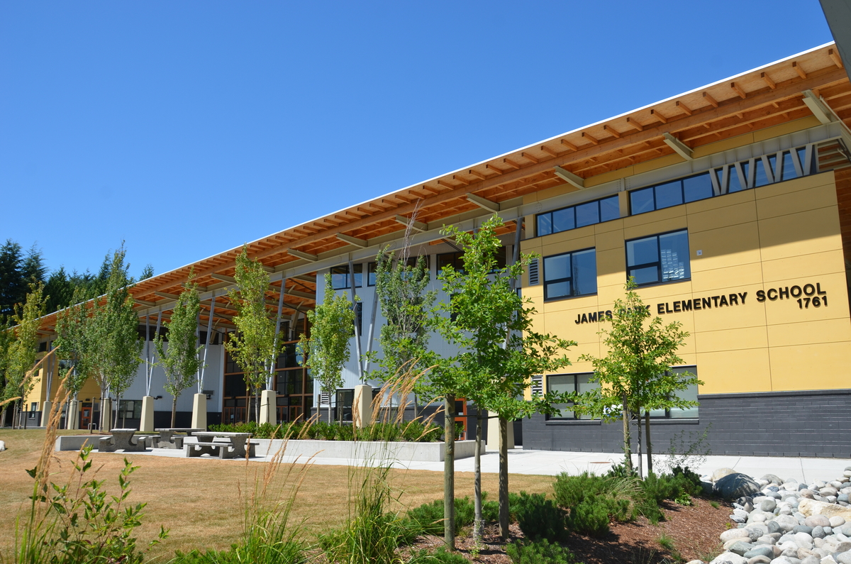 Exterior daytime view of two storey energy-smart and LEED certified James Park Elementary School showing amply exposed wood roof construction