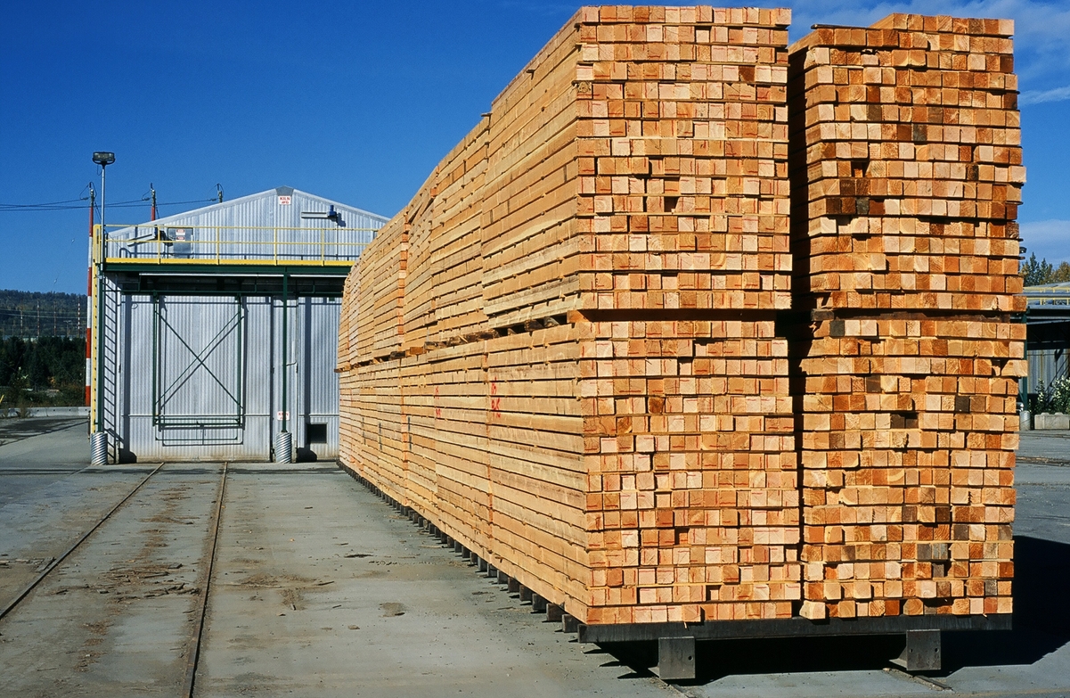 Five deep stack of kiln dried lumber loaded onto kiln track cart after exiting one door of a double track kiln - as part of the drying process