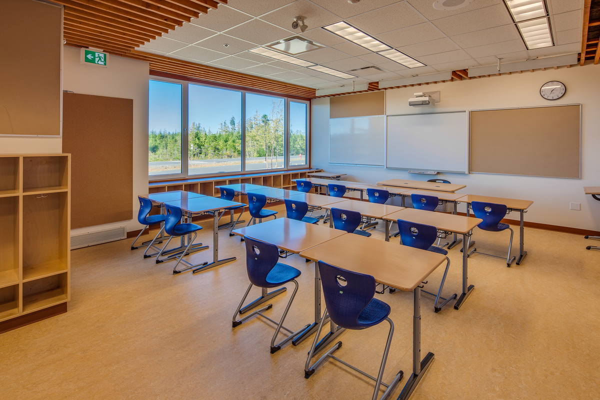 Wood flooring, desktops, cubicles, and hybrid ceiling construction feature prominently in this interior view of a Kwakiutl Wagalus School classroom