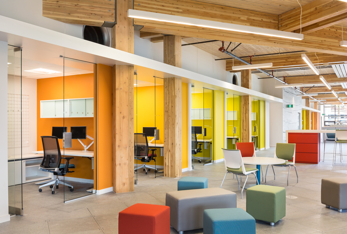 Interior view of completed MEC Headquarters building showing individual offices and communal working area, all featuring mass timber construction, Glue-laminated timber (Glulam), Nail-laminated timber (NLT), and abundant millwork
