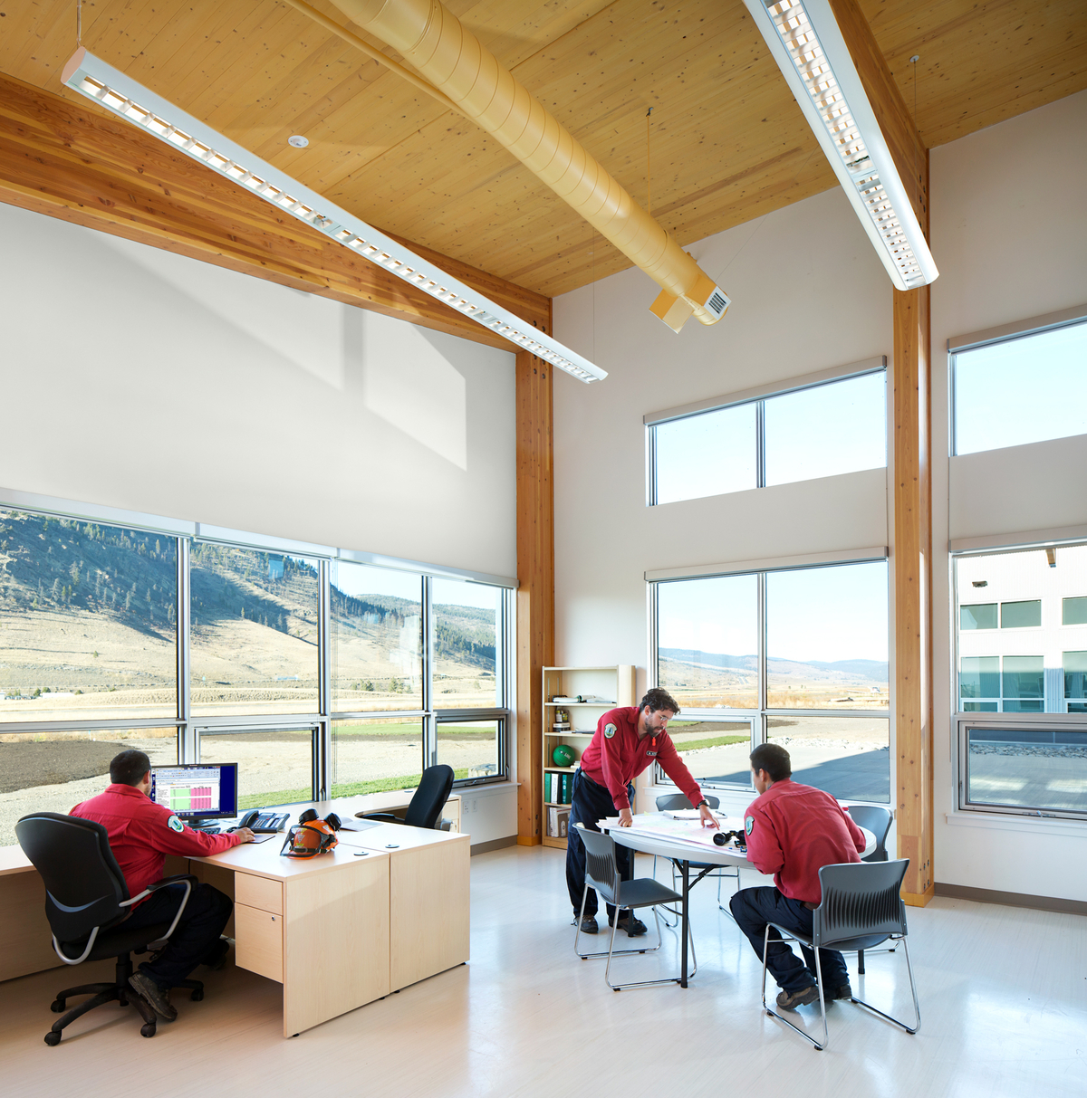 Occupied interior daytime view of low rise Merritt Fire Zone Office and Provincial Wildfire Training Centre showing combination of glue-laminated timber (glulam) post and beam and light wood-frame construction
