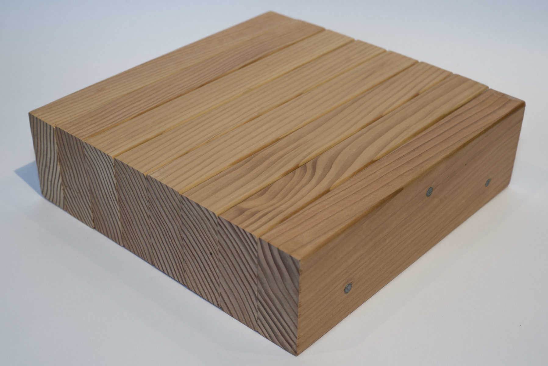Close up of demonstration section of nail-laminated timber (NLT) showing 8 dimension lumber segments stacked together on edge and fastened together with nails to form a solid structural element
