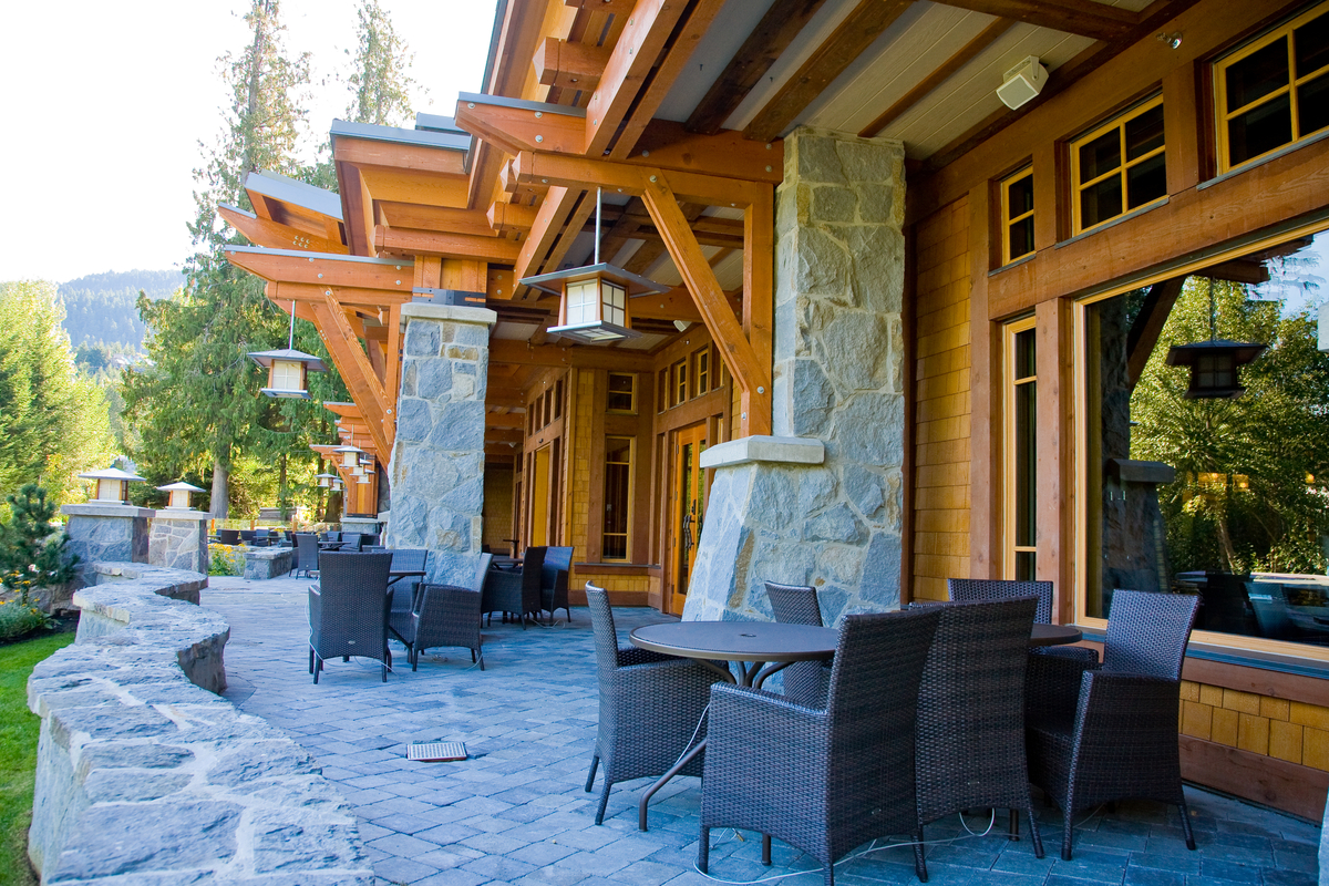 Exterior daytime view of Nita Lake Lodge exterior rock and wood constructed walkway & seating area, showing extensive use of wood, including millwork, plywood, solid-sawn heavy timber, Post + beam