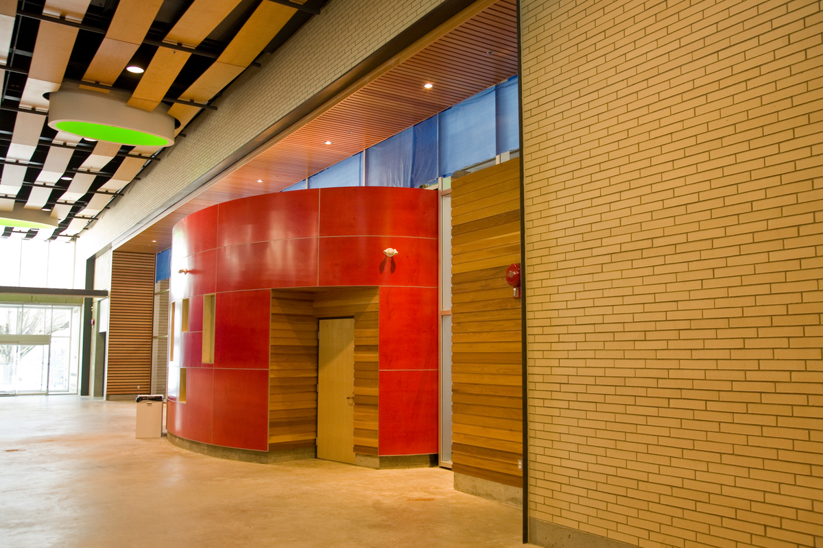 Interior daytime image of low rise Hillcrest Centre main entrance hallway showing extensive use of wood, including ceiling of exposed undulating wood panels