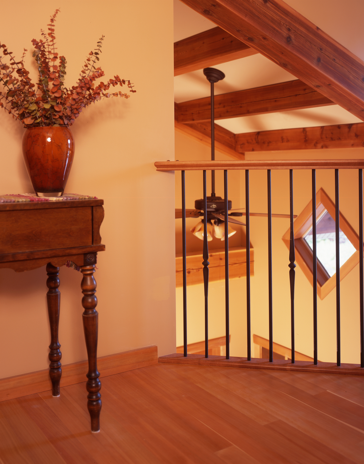 Daytime interior image of upper floor landing and railing with extensive use of wood for trim, flooring, and ceiling beams - used as Western Larch (Larix occidentalis) usage examples