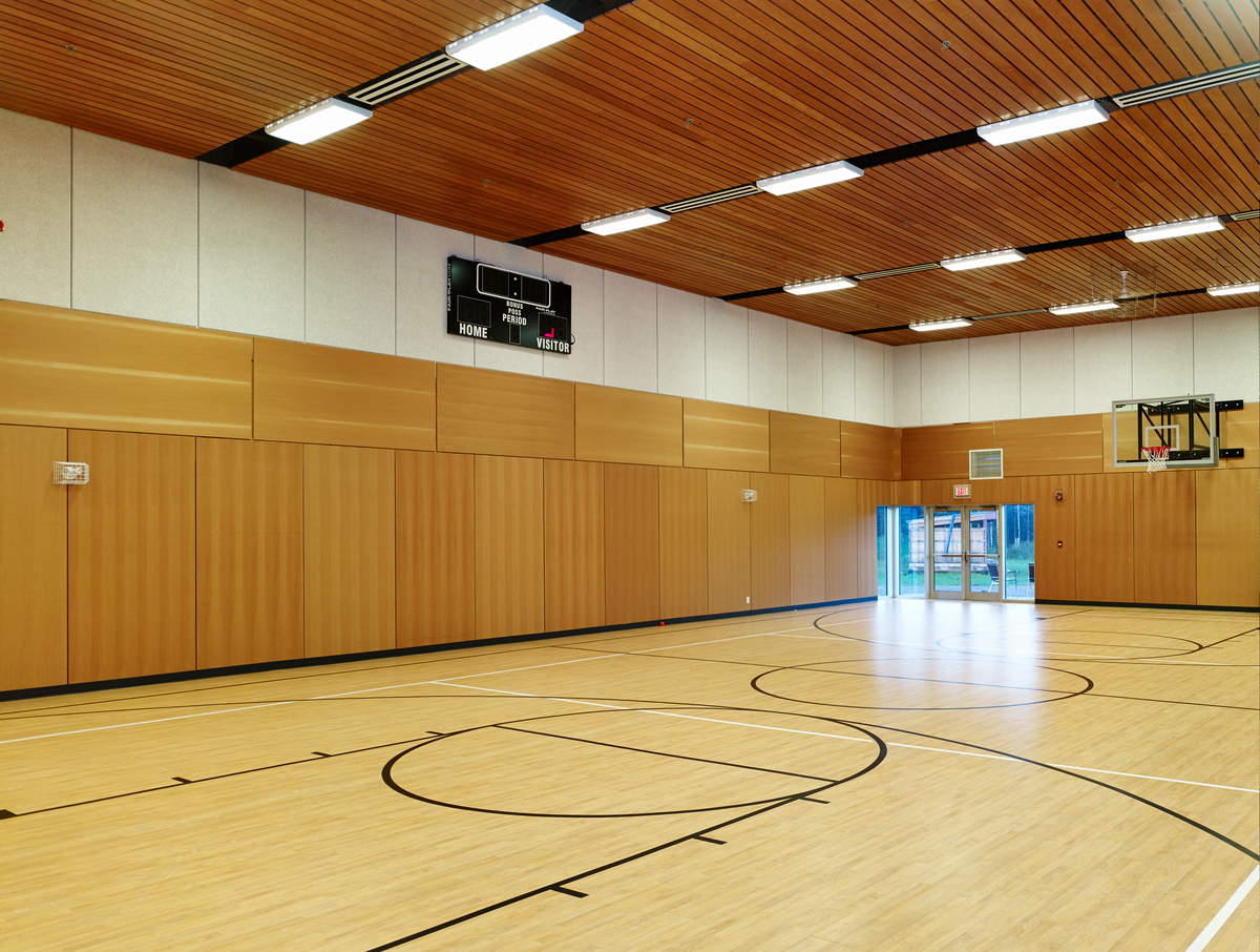 Interior daytime image of brightly lit Prophet River Multiplex gymnasium showing hardwood floors, wood paneling, and wood ceiling decking
