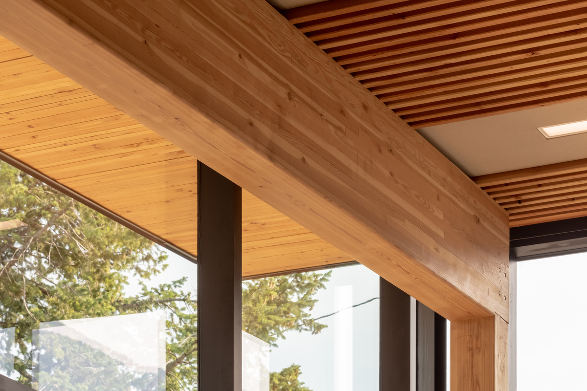 Close up interior daytime view of Radium Hot Springs Community Hall and Library showing glue-laminated (glulam) timber bean supporting dowel laminated timber (DLT) roofing sections