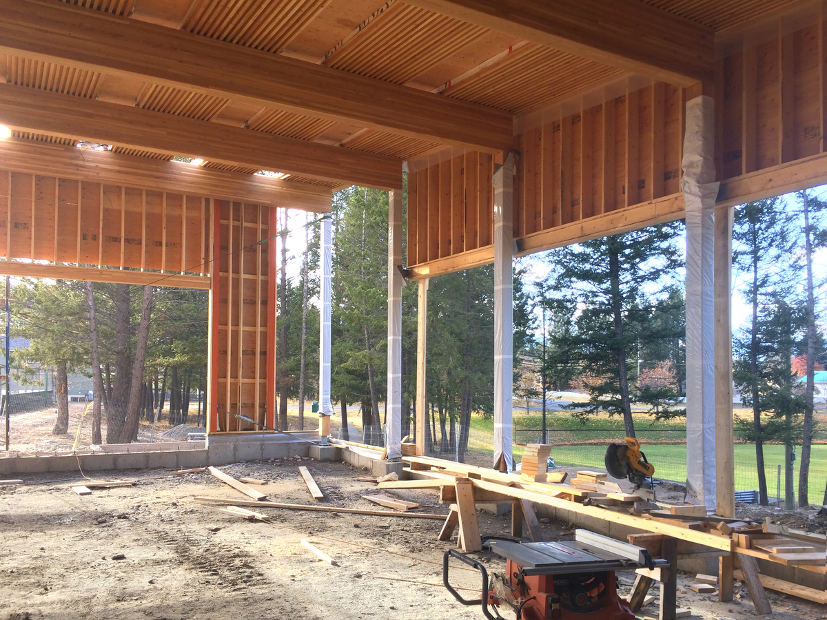 Exterior daytime view of under construction Radium Hot Springs Community Hall and Library showing dowel-laminated timber (DLT) beams, light frame walls, and mass timber columns