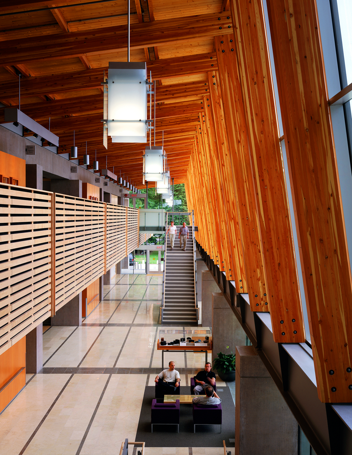 Interior daytime view of Richmond City Hall three-storey galleria showing use of Glue-laminated timber (Glulam) beams and columns supporting expansive solid-sawn heavy timber decking roof