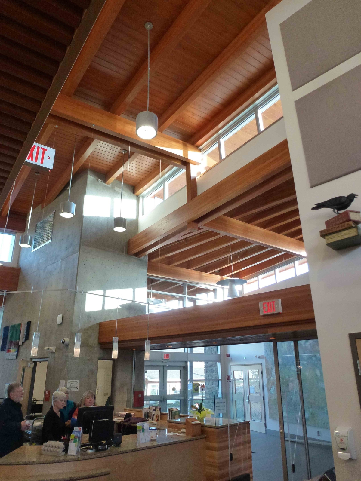 Interior upward close up daytime view of Salt Spring Island Library ceiling structure, showing glue-laminated timber rafters as a component of acoustic linear wood ceilings, which muffle noise to help preserve a quiet, peaceful atmosphere