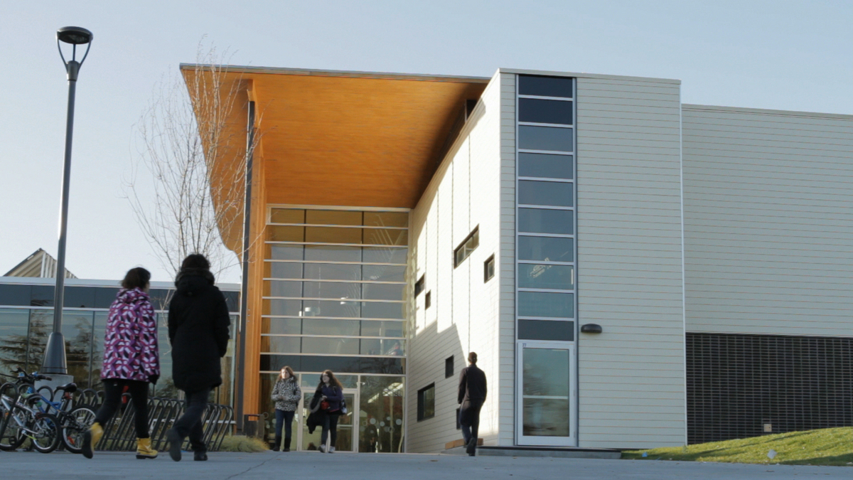 Exterior daytime view of Samuel Brighouse Elementary showing students, multi-storey entrance, and demonstrating mass timber and hybrid timber construction