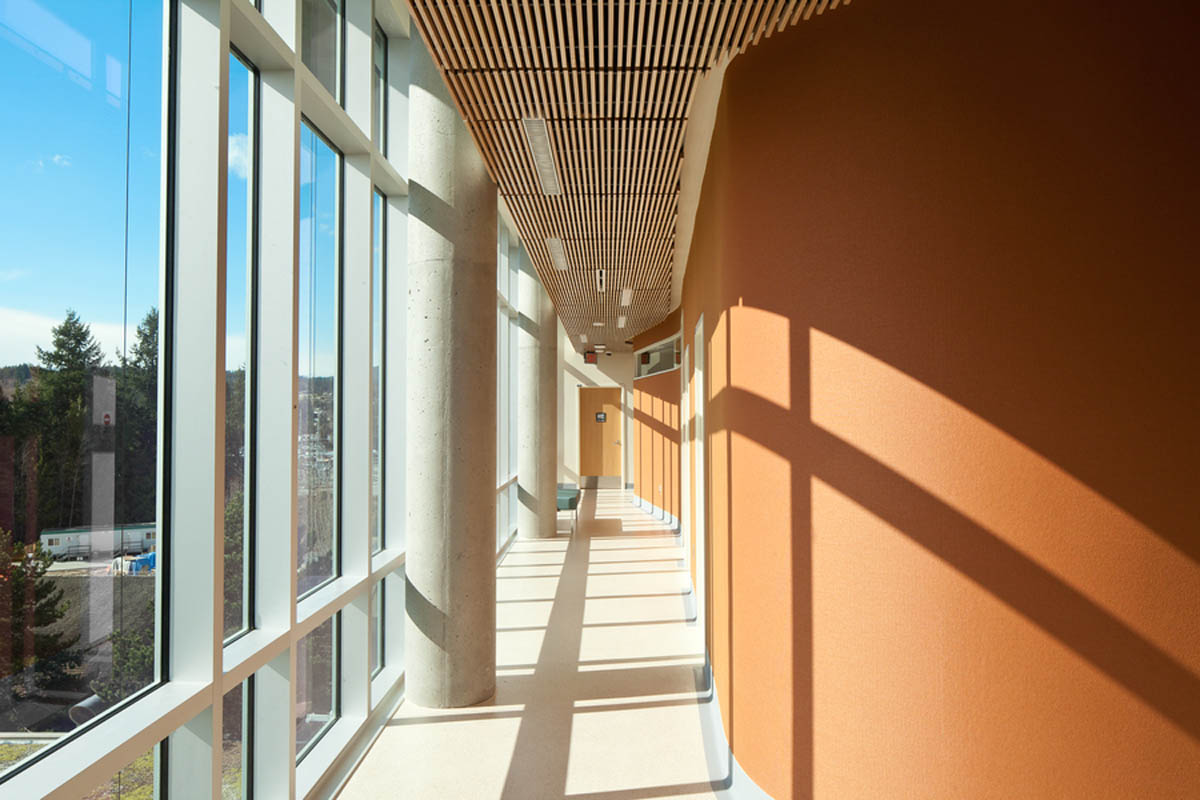 Sechelt Hospital interior with sunlight on terracotta walls with wooden millwork on ceiling