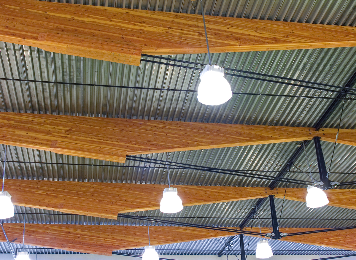 Interior close up image of hybrid Sk’elep School of Excellence showing gymnasium ceiling, which features an elegant hybrid between glue-laminated timber (glulam) beams and a king-post truss