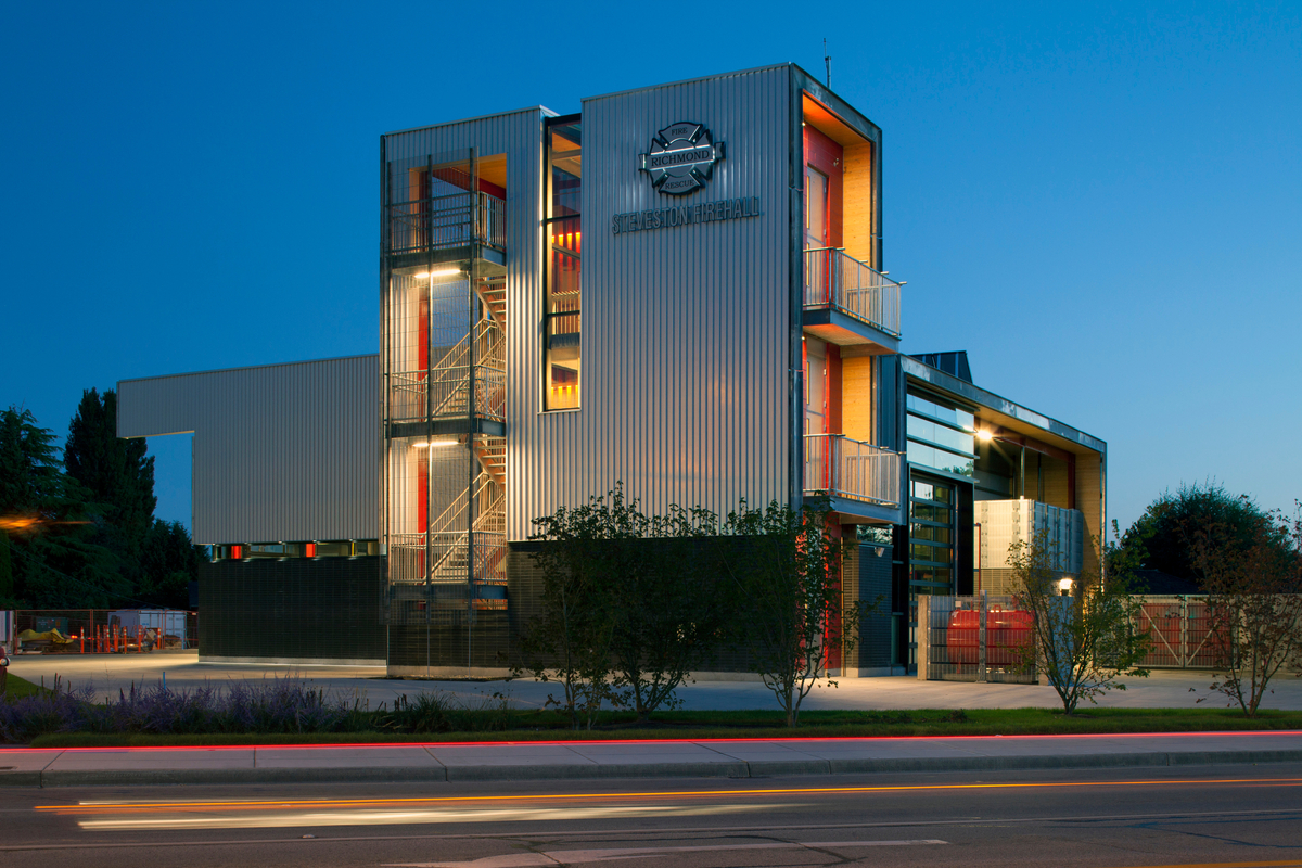 Exterior evening across the street view of Steveston Fire Hall No. 2 showing hybrid metal, wood and glass construction and including solid mass timber panels, post + beam, siding, and laminated veneer lumber (LVL)