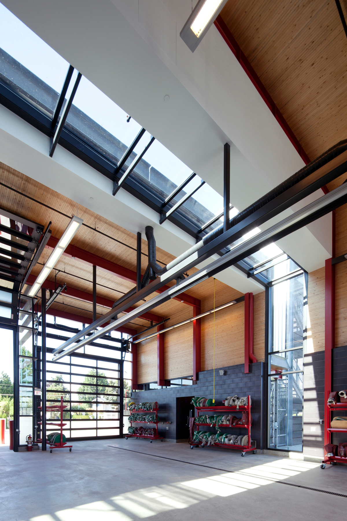 Nail laminated timber (NLT) solid-wood decking, used for the roof and wall panels, is shown in this interior vehicle bay image of the low rise hybrid Steveston Fire Hall No. 2