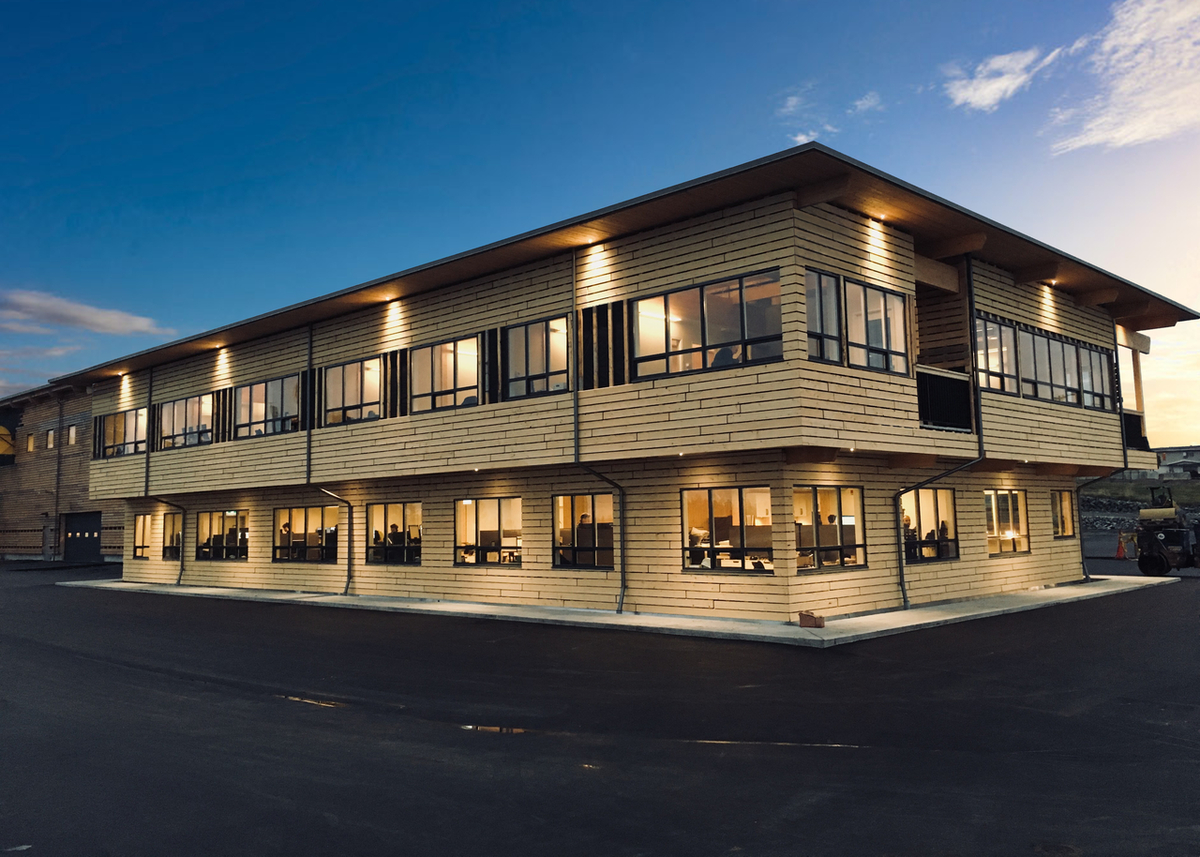 Exterior evening view of low rise StructureCraft Facility showing extensive use of exterior wood paneling