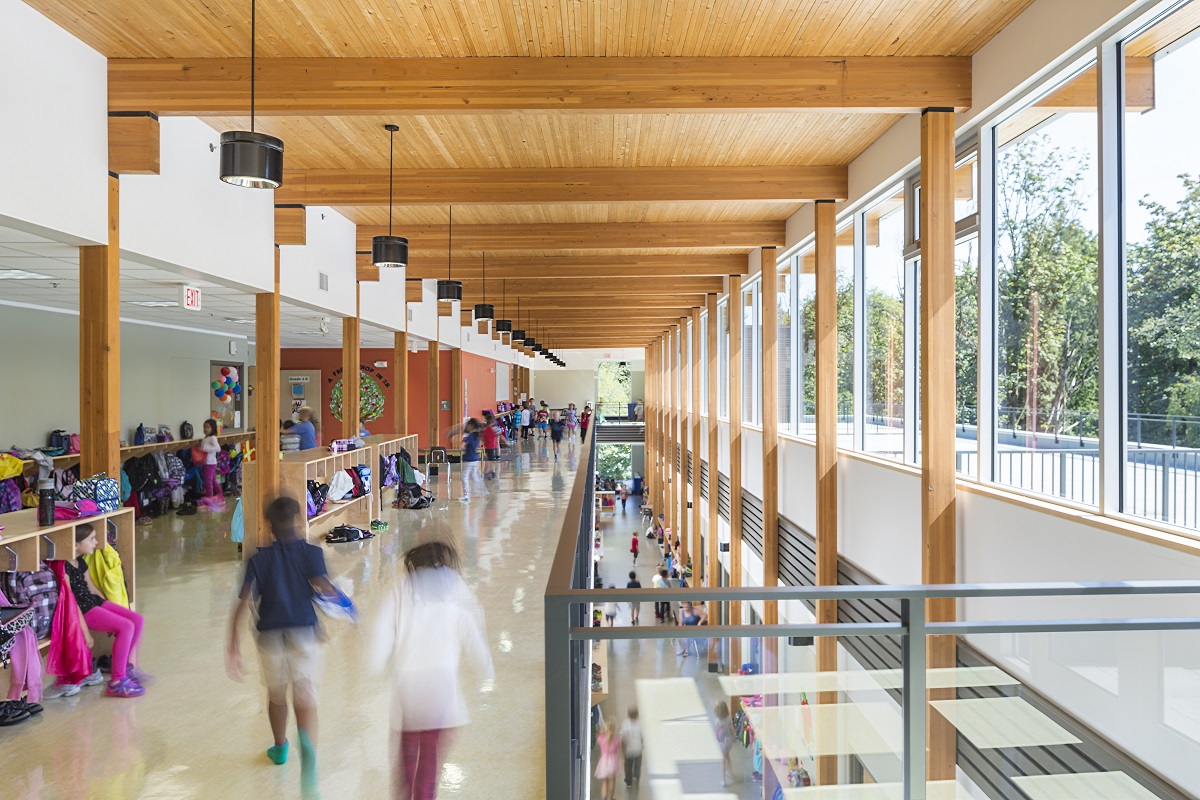 Sunny daytime second floor view of children inside Surrey Christian School Primary Wing showing mass timber construction, including glue-laminated timber (Glulam), and cross-laminated timber (CLT)