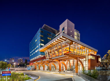 Exterior view of Surrey Memorial Hospital Critical Care Tower showing biophilic glulam arches that extend floor to ceiling, bringing warm stress-reducing tones to critical care patients.