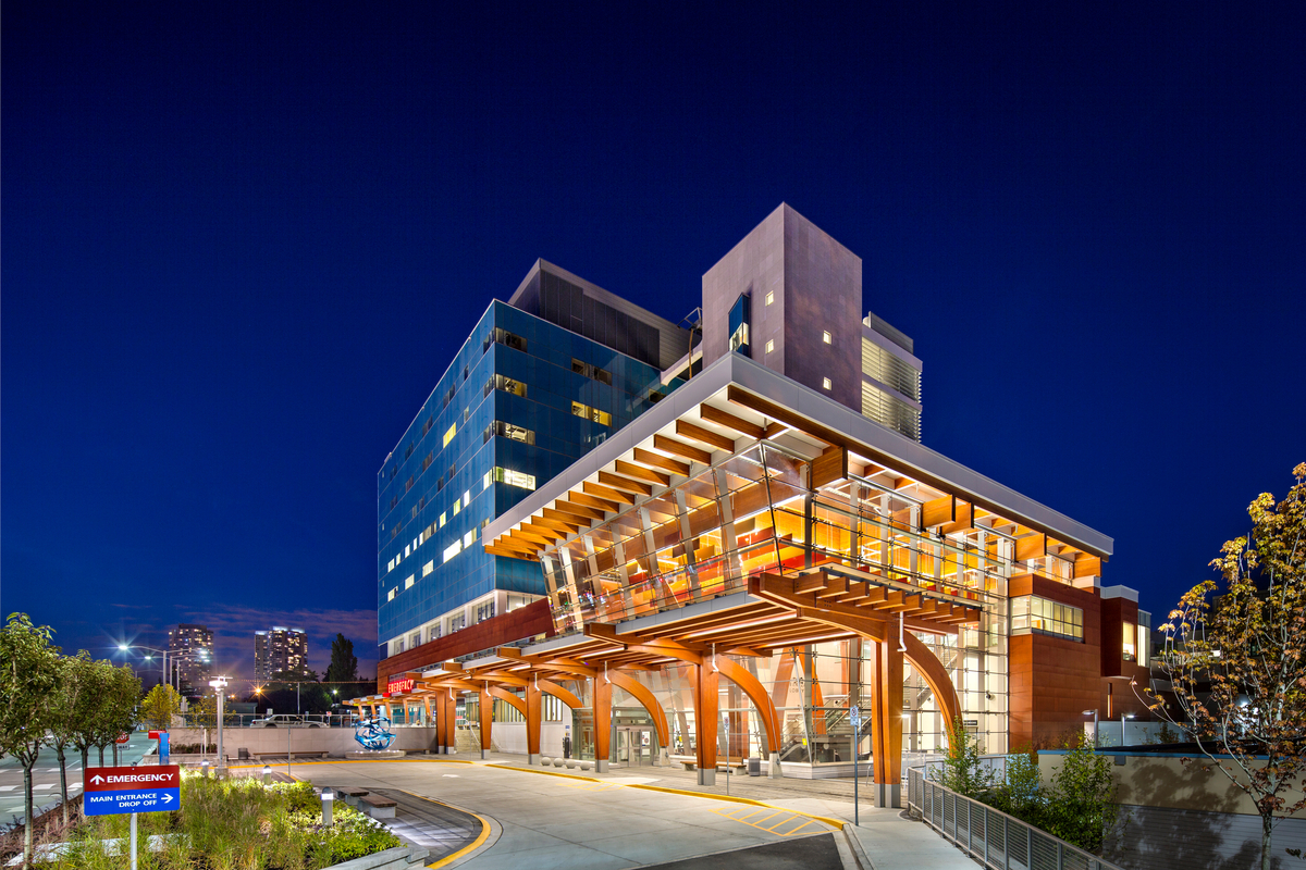 Exterior view of Surrey Memorial Hospital Critical Care Tower showing biophilic glulam arches that extend floor to ceiling, bringing warm stress-reducing tones to critical care patients.