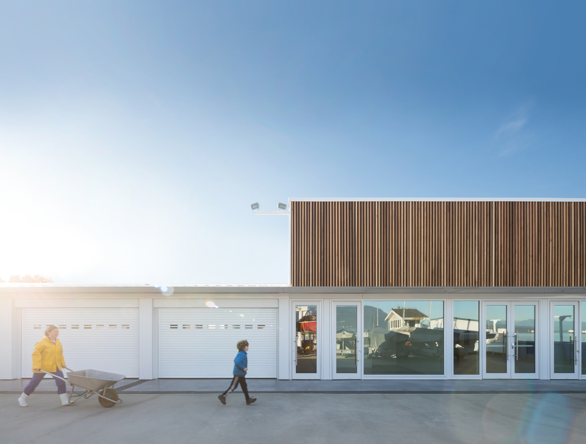 Sunny daytime exterior image of the Dock Building at the Royal Vancouver Yacht Club which combines glue-laminated timber (glulam), dimension lumber and plywood, creating a functional storage and workshop facility