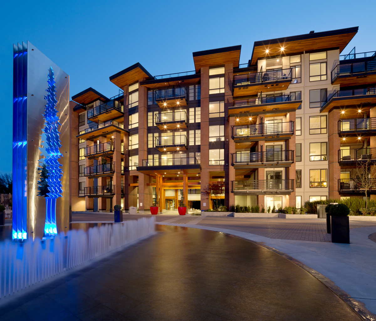 Exterior evening view of multi-storey 28,000 square metres 'The Shore', a multi-building residential development, with many large wooden decks and balconies
