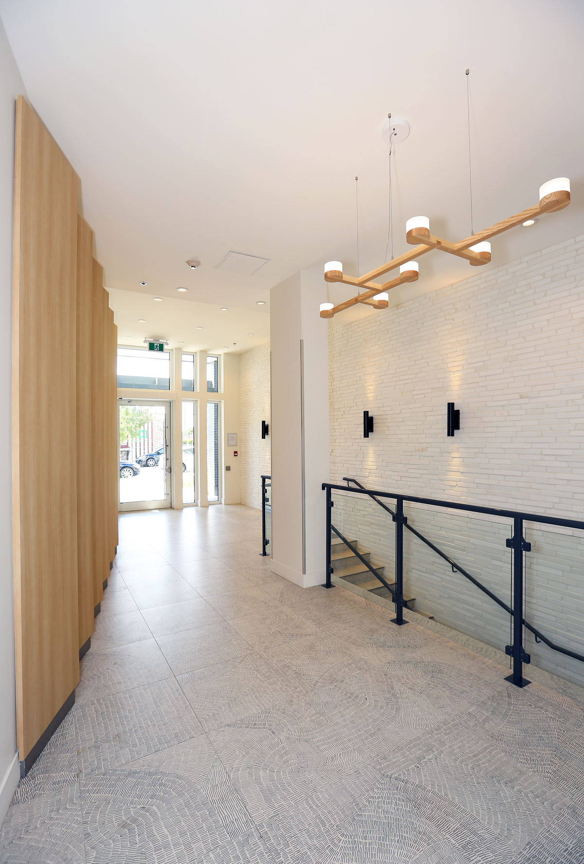 Interior entrance view of The Heights, mixed-use project with five storeys of light wood-frame residential dwellings, showing wood accents and trim