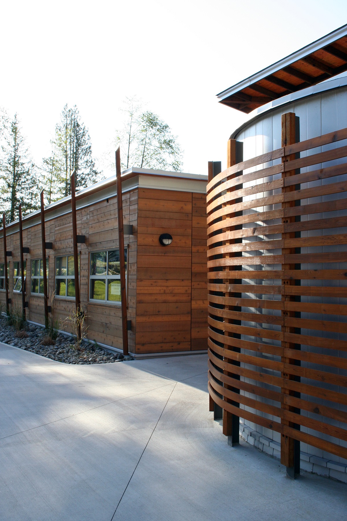 Exterior afternoon view of low rise Tla'Amin Community Health Services building showing extensive use of wood siding and decorative wood trim