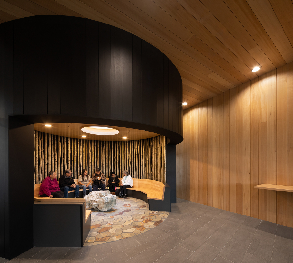 Interior view of Ts’kw’aylaxw Cultural and Community Health Centre circular social area showing comprised of Douglas-fir glue-laminated timber (glulam) columns and prefabricated light wood frame panels