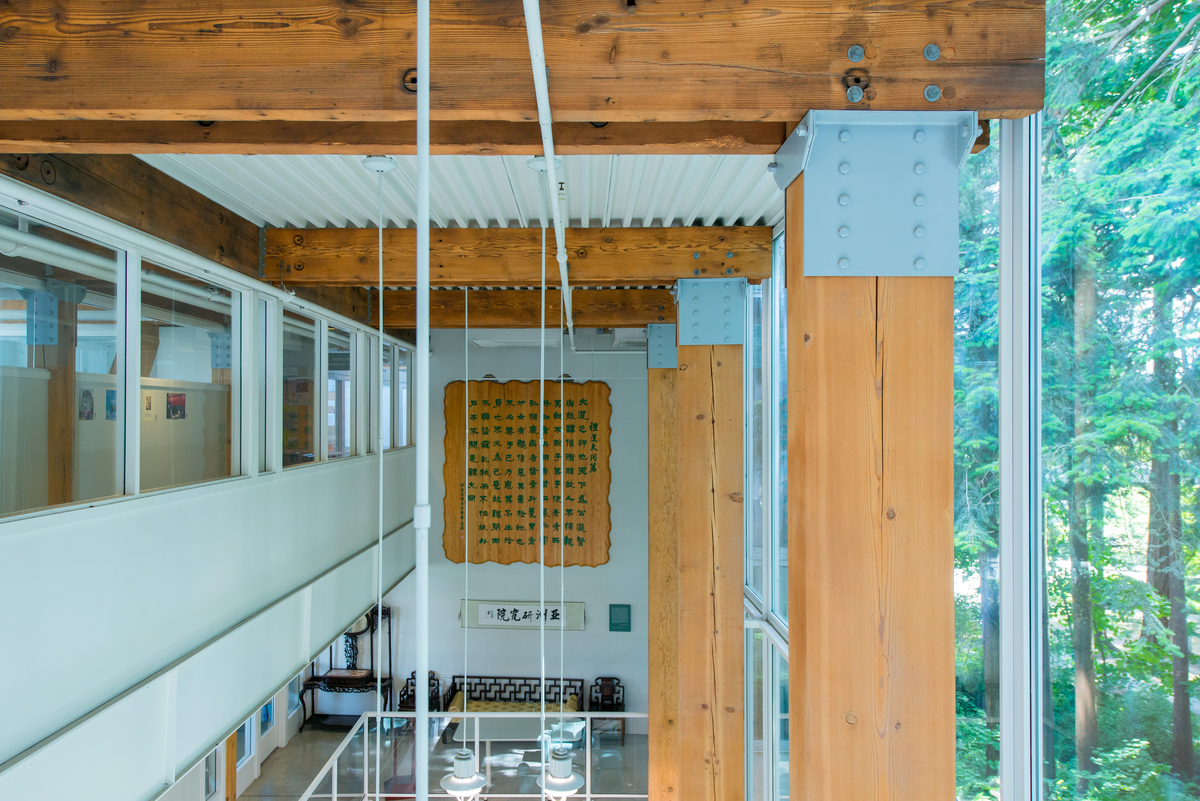 solid-sawn heavy timber beams and columns, with associated metal mating plates, and shown in this upper floor image at the UBC CK Choi Building atrium area with glazed exterior