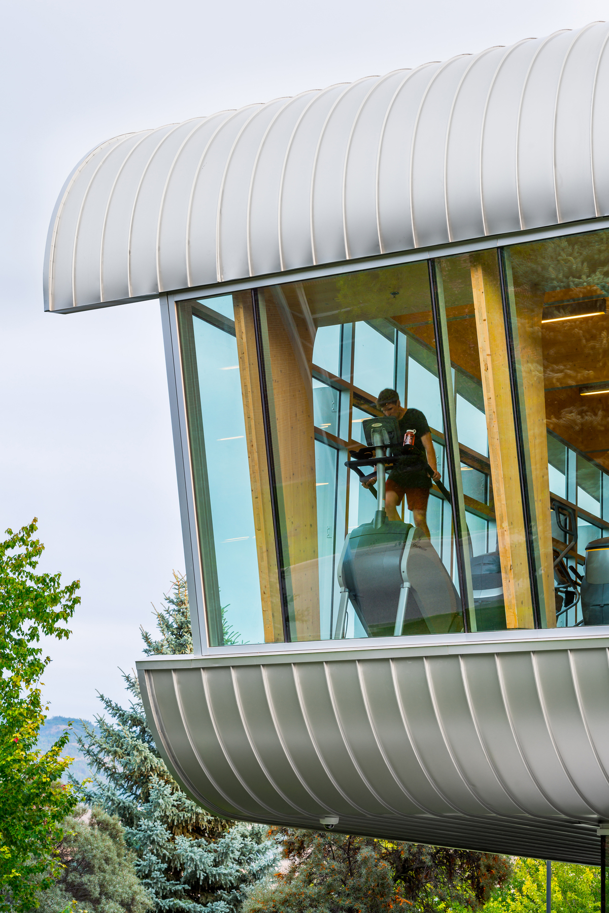 Exterior daytime view of hybrid two-storey UBCO Fitness & Wellness Centre, showing hybrid metal and glazed exterior with cross-laminated timber (CLT) and glue-laminated timber (Glulam) elements inside