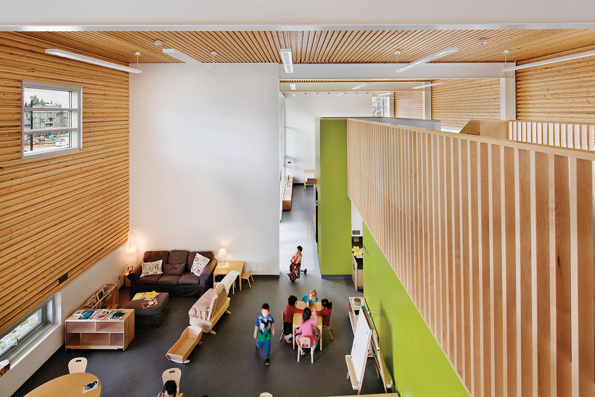 Interior daytime view of UniverCity Childcare Centre showing Nail-laminated timber (NLT) panels, made from salvaged wood affected by the mountain pine beetle infestation, create a corrugated surface that adds visual interest and improves the acoustics of the busy activity spaces